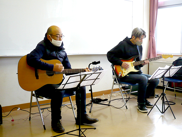 50代男性の生徒さんと講師のギター演奏の様子