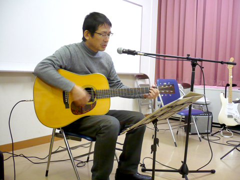 50代男性の生徒さんのギターの弾き語りの写真