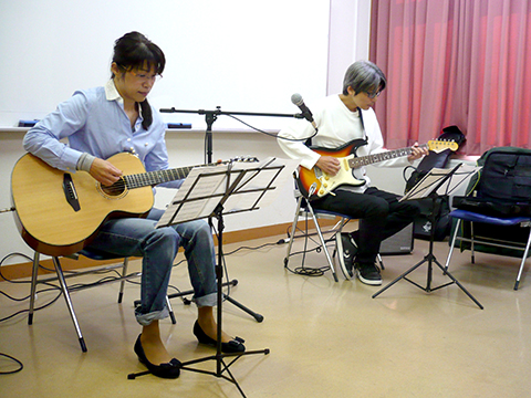 40代女性の生徒さんと講師のギター演奏の写真