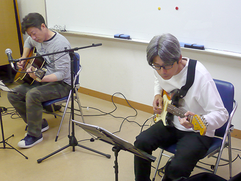 40代男性の生徒さんと講師のギター演奏の写真
