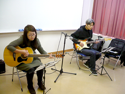 50代女性の生徒さんと講師のギター演奏の様子