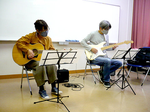 50代女性の生徒さんと講師のギター演奏の写真