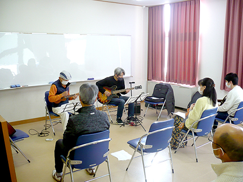 ウクレレを弾く生徒さん（70代男性）と講師の演奏の様子