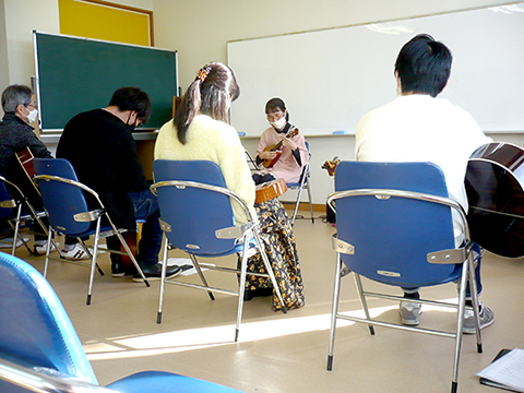 ウクレレの生徒さん（50代女性）の演奏とそれを聴く生徒さんたちの様子