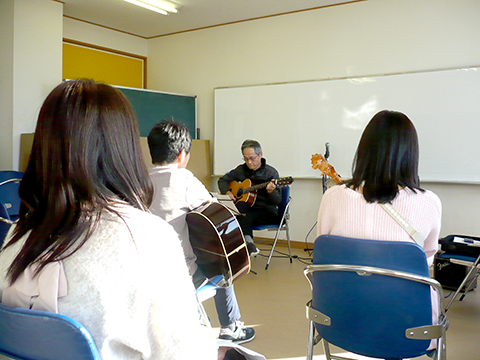 70代男性の生徒さんのギター演奏とそれを聴く生徒さんたちの様子