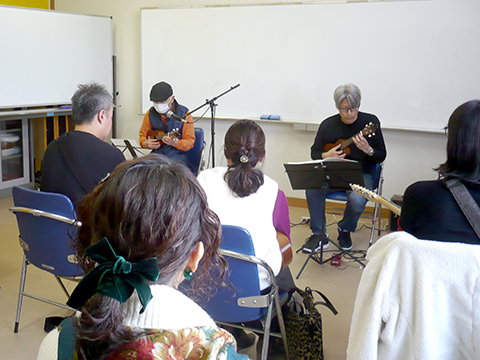 80代男性と講師のウクレレ演奏とそれを聴く生徒さんたちの様子