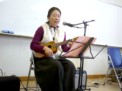 ウクレレを弾き語りする50代女性