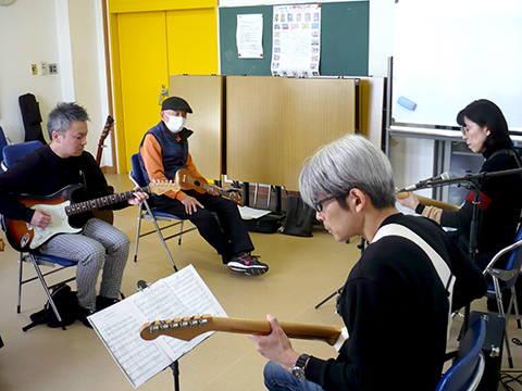 50代女性と講師のエレキギターのデュオ演奏の横からの様子