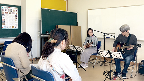 ウクレレの50代女性とギターを弾く講師の様子2