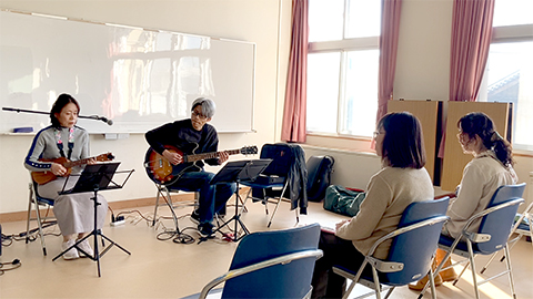 ウクレレの50代女性とギターを弾く講師の様子