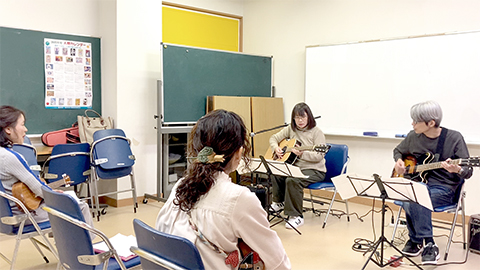 50代女性と講師のギター演奏の様子